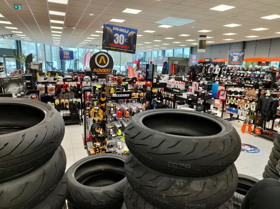 Showroom de motos spacieux et lumineux, vitres panoramiques, sol carrelé beige