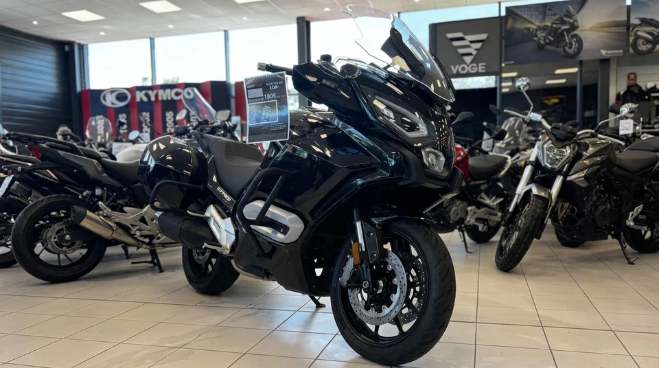 Showroom de motos spacieux et lumineux, vitres panoramiques, sol carrelé beige