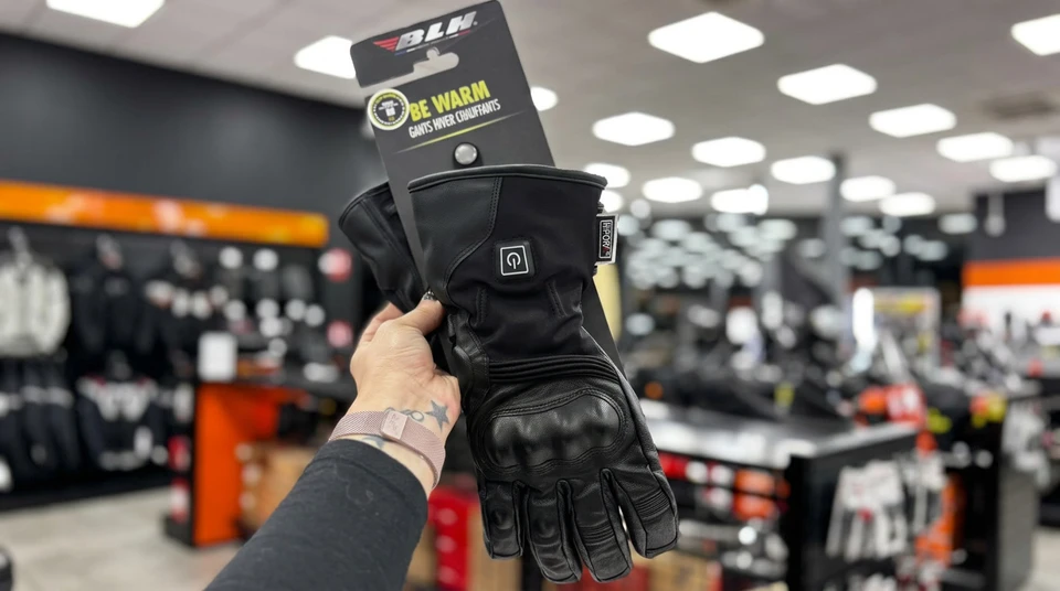 Magasin de moto en intérieur, rayons bien achalandés, présentoirs d'accessoires, casques, équipements et vêtements
